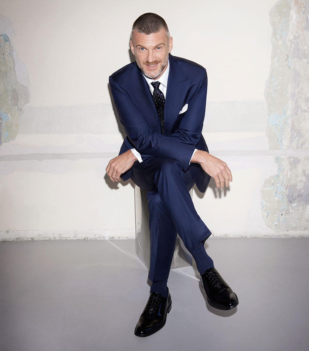 Mężczyzna w granatowym garniturze marki Vistula.