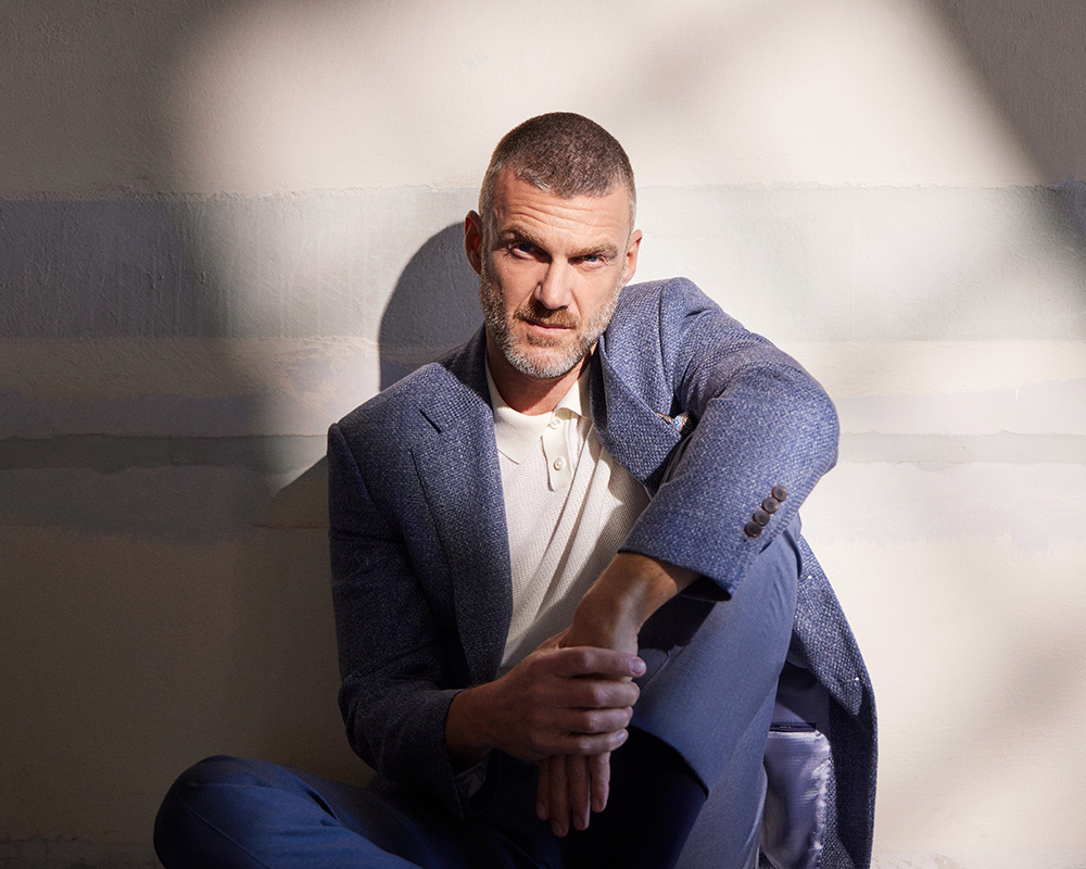 Mężczyzna w niebieskiej marynarce marki Vistula.