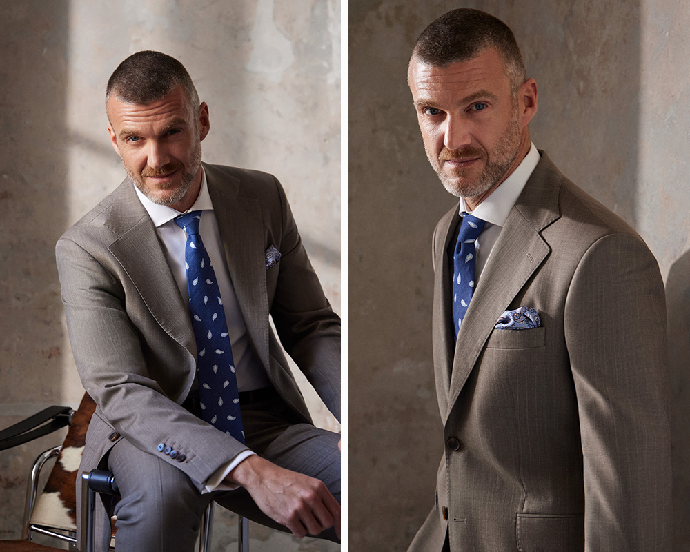 Mężczyzna w eleganckim garniturze z krawatem i poszetką.