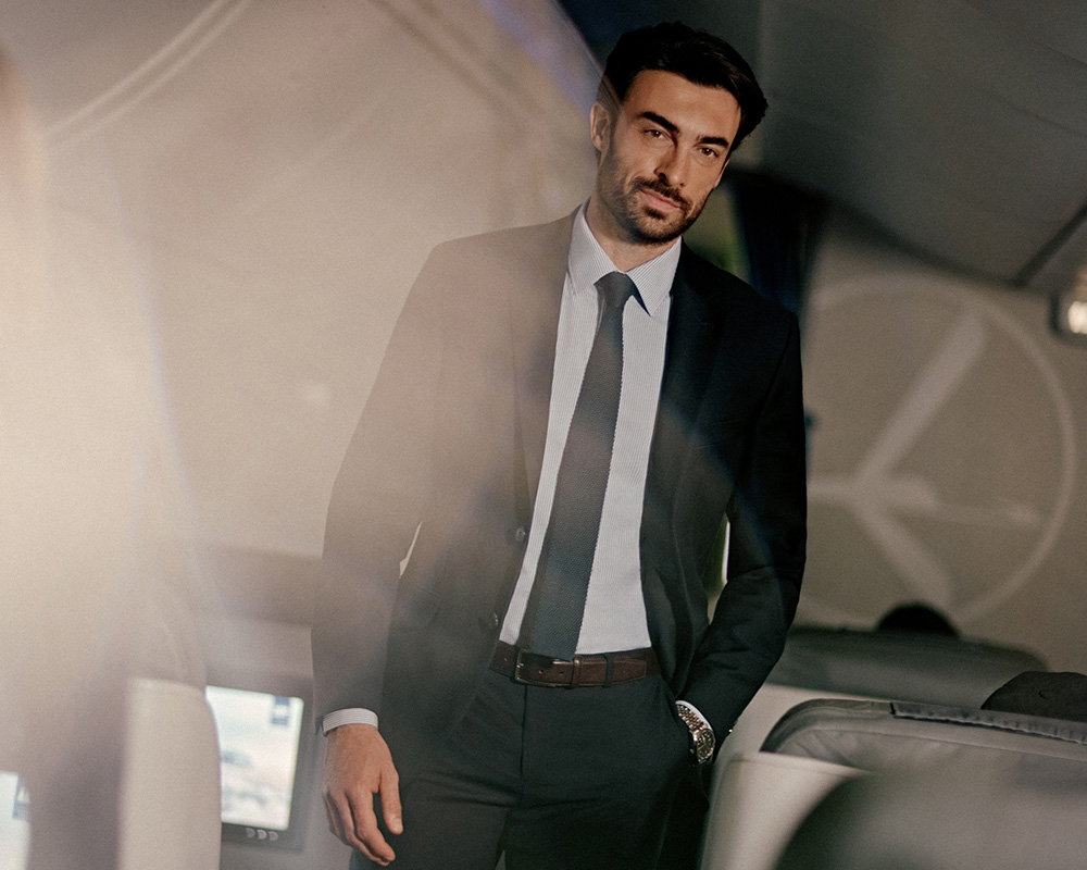 Mężczyzna w garniturze stoi w samolocie