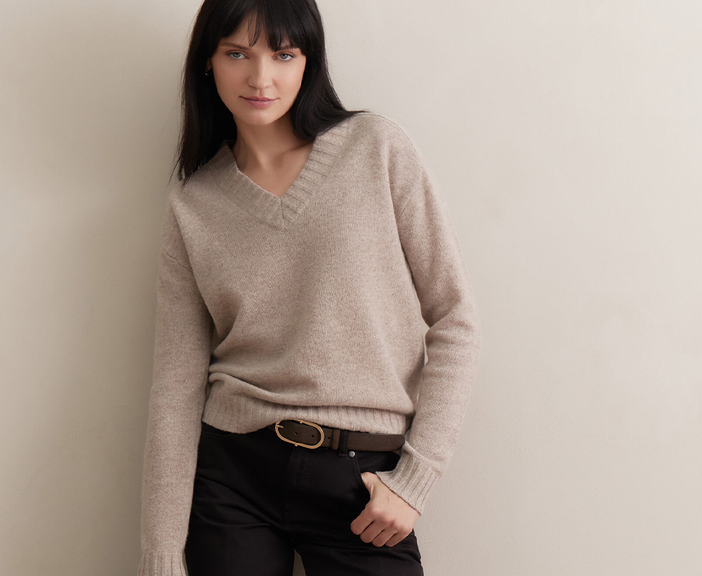 Kobieta w beżowym swetrze v-neck z wełny merino z nowej kolekcji marki Vistula